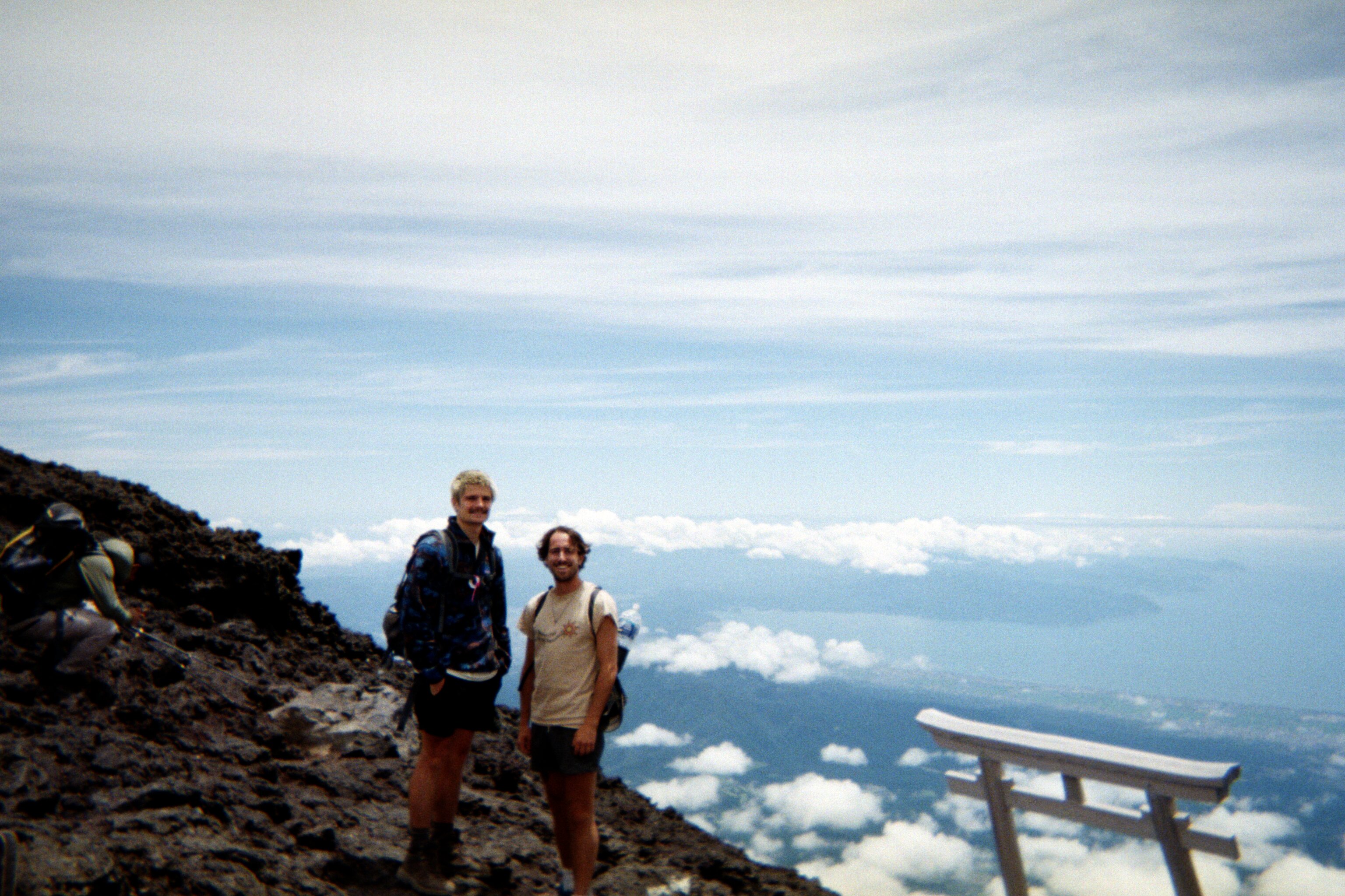 Santo and a friend posing at the summit of Mount Fuji above the clouds